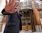 BAD TIMES  A security guard tries to stop a photographer taking pictures of the offices of Goldman Sachs in London, AFP