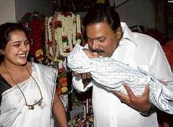 Mayor S K Nataraj kisses his one-month-old grandson before leaving for his office in Sarakki on Monday.  DH photo