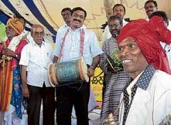 Begin with a bang: President of Backward Classes Commission C S Dwarakanath, inaugurating the seminar on nomadic dalit communities by beating the drum in Theralli Betta on Wednesday. Prof M H Krishnaiah and Kotiganahalli Ramaiah are also seen. DH PHOTO