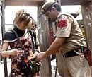 A police man frisks a foreign tourist at a market in New Delhi on Sunday. AP