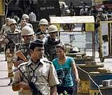 High Alert: Paramilitary troops patrol as a woman walks outside Arthur Road Jail, where the trial of Mohammad Ajmal Kasab is being held, in Mumbai on Tuesday.  Reuters