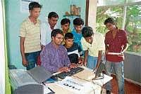 Students looking at the marks list on website at internet centre. The number of students thronging to see their results at the the notice board has reduced drastically after online anouncement of results started. DH Photo