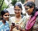 Quick Check: Students of MES College accessing PUC results through mobile phones in Bangalore on Thursday.  DH Photo