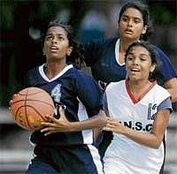 Aaiming high:  Rajmahals N Anaga (left) moves past VNS Trisha in the State Youth basketball championship. DH photo
