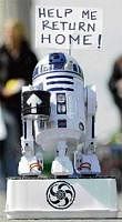 Showing a human face, the robot R2D2 from the Star Wars movies collects money for his journey home in front of the Brandenburg Gate in Berlin. AFP