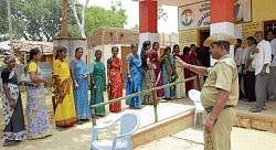 Voters waiting at the Grama Panchayat election at Kammasandra, Hoskote on Saturday.  DH Photo