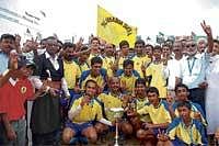 Triumphant:  Palanganda players pose with the Maneyapanda trophy in Ponnampet on Sunday. Palanganda scored a 4-2 win over Mukkatira, Bonda in the final. DH photo