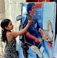 reap what you sow: A child slaps a poster of Pakistani terrorist Ajmal Kasab with a slipper while celebrating the death sentence awarded to him in Mumbai on Sunday. PTI