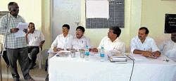 DDPI Prahalada Gowda taking a headmaster to task at a meeting on poor performance in SSLC examination, in Kolar on Monday. DH photo