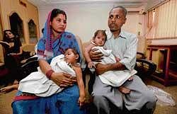 double relief: Nirmala and her husband Subhash Mukhia hold conjoined twins Gita and Sita respectively at a press conference after their successful operation in New Delhi on Wednesday. AP