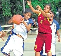 Out of my way! Janani of Ulsoor Sports Union (left) tries to dodge past Lavanya of Sports Hostel, Vidyanagar in the State Youth basketball tournament on Wednesday. DH Photo