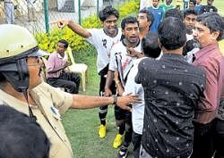 Tempers flare:  A police officer and organisers try to pacify Vasco players at the Bangalore Football Stadium. DH photo