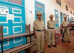 Policemen guarding the strong  room where  ballot boxes are kept at Rosario PU college in Mangalore on Thursday. DH photo