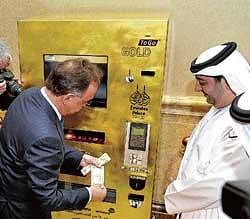 gold diggers: Thomas Geissler, the chief executive of TG-Gold-Super-Markt, tries the Gold to Go vending machine at the Emirates Palace Hotel in Abu Dhabi on Wednesday. AFP