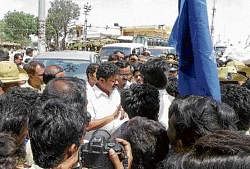 Demanding answer: Karnataka Dalit Sangharsha Samiti members gheraoing Excise Minister Renukacharya in Dibburahalli in Shidlaghatta taluk on Thursday. DH Photo
