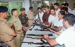 Trainees having a feel of the weapons at the Civilian rifle training camp in Mangalore on Friday. DCP Ramesh looks on.