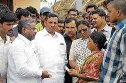 consolation Leader of the Oppotion in the Legislative Council Motamma, Union Minister for Railways K H Muniyappa and MLA V Muniyappa offering compensation to the families of the  hooch tragedy victims in Shidlaghatta on Saturday. DH photo