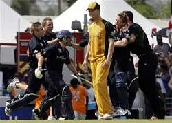 Australia's captain Michael Clarke, foreground center, walks off the pitch as England's players celebrate their victory at the Twenty20 Cricket World Cup final match in Bridgetown, Barbados on Sunday. AP