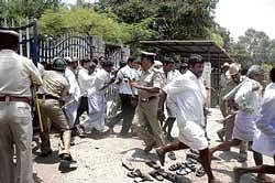 Police caning the supporters of GP candidates at a counting centre in Bellary on Monday. dh Photo