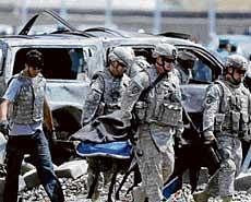 deadly strike: US soldiers carry a body from the site of a suicide car bomb attack in Kabul on Tuesday. REUTERS