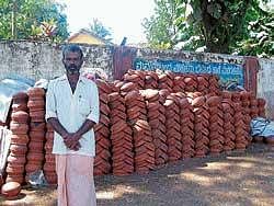 still in demand K T Murugan with earthen utensils in front of the Forest Department in Narasimharajapur. DH photo