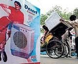 Labourers load an air cooler for a customer as the temperature rose  in New Delhi on Tuesday.  PTI