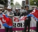 South Korean conservative activists tear North Korean flags during a rally against the communist neighbor in front of the Defense Ministry in Seoul on Thursday. AP