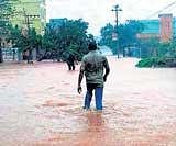 A man wades through a flooded street in Ongole district, Andhra Pradesh, on Friday. PTi
