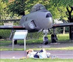 A South Korean takes a nap near a fighter jet used in Korean War, displayed at the Korean War Museum, on Friday. AP