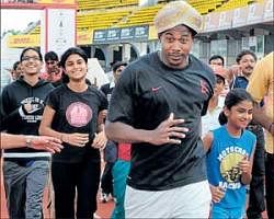 Fun run: Olympic gold medallist Shawn Crawford jogs along with young Karnataka athletes at the Sree Kanteerava stadium in Bangalore on Saturday. DH Photo/Kishor Kumar Bolar