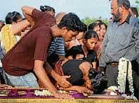 Mother and relatives of the deceased couple Naveen Fernandes and Saritha DSouza, weeping before their coffins at Holy Cross Church cemetery in Kulshekar in Mangalore on Monday.