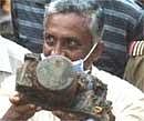 Vital Clue: A Directorate-General of Civil Aviation staffer shows an aircraft part, which officials claim is the black box of the doomed Air India Express flight 812, recovered from the crash site in Mangalore on Tuesday. AFP