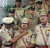 An officer adjusts the scarf of another officer during the group photo session after receiving medals at the Karnataka Home Guards Presidents medal distribution ceremony organised at the Raj Bhavan in Bangalore on Tuesday. DH Photo