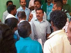 Zilla Panchayat Member S N Ramaswamy speaking to farmers at the protest in front of the Agriculture Department Office at Balagadi in Koppa on Tuesday.