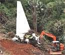 An earth remover cleaning the debris of crashed Air India plane in Mangalore on Monday. 158 persons were killed in the crash on Saturday. PTI
