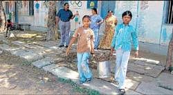 Students of government school in PC Colony in Kolar  engaged in cleaning work on Friday. DH PHOTO