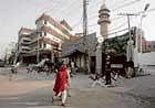 Women walk past the Garhi Shahu mosque which was ambushed by militants on Friday, in Lahore on Saturday.