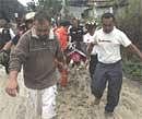 People carry the body of a victim, killed during mudslides caused by the tropical storm Agatha, in Guatemala City, Sunday. AP