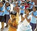 Children of the Government school in Kurubarpet of Kolar at the prayer meeting on the first day of the academic year on Monday.  DH PHOTO