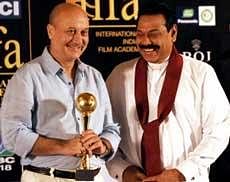Sri Lanka President Mahinda Rajapakse (R) greets Indian actor Anupam Kher after presenting an award at a business promotion meeting in the capital Colombo . AFP