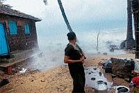 Natures Fury: A woman looks on as sea waves attack her house in Ullal on Sunday.  DH Photo