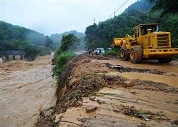 In this Monday, June 14, 2010 photo released by China's Xinhua News Agency, an excavator works at the site of an accident where a rain-triggered landslide engulfed two vehicles in Nanping, east China's Fujian Province.