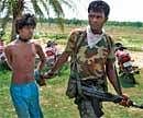 A security person catches hold of an alleged cadre of the Maoists after a gun battle with the ultras and a joint team of security forces, at Deult village in West Midnapore on Wednesday. PTI