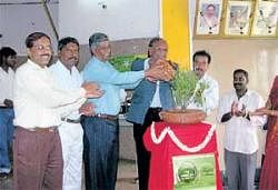 For secure: earth Karnataka State Pollution Control Board chairman A S Sadashivaiah watering a plant  to inaugurate World Environment Day celebration  in Chikkaballapur on Wednesday. Deputy Commissioner Anwar Pasha,  Deputy Conservator of Forests Jayaramegowda join hands. DH photo