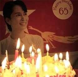 Birthday candles are lit in front of an image of Myanmar's detained opposition leader Aung San Suu Kyi during party of her 65th birthday at a party member's home in Yangon. AP