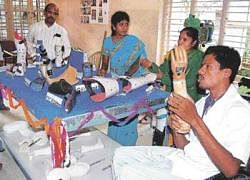 Narasimha Murthy, an expert in producing assistive devices, gives information about an artificial limb made by him at Navachetana centre in Kolar. DH photo