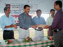 Zilla Panchayat CEO A B Ibrahim distributing aides to the beneficiaries after inaugurating gobar gas unit in Madikeri on Monday.