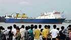 People watch the Pak-bound ship M V Aegean Glory which was brought to Kolkata port from Diamond Harbour after it was found loaded with explosives on Sunday. PTI