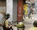 Youths throw stones at the police during a protest rally in Srinagar on Tuesday. AP