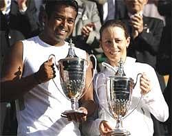 India's Leander Paes, left, and his partner Zimbabwe's Cara Black hold their trophies after winning in the mixed doubles final at the All England Lawn Tennis Championships at Wimbledon, Sunday. AP
